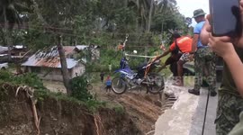 Locals use make-shift pulley to cross bridge which collapsed during storms in the Philippines