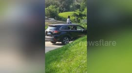 Girl sits on top of car while it moves in Beijing Safari Park