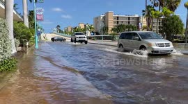 Vehicles in south Florida drive through flooded roads caused by rising sea levels and king tides