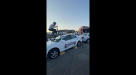 Skilful BMX pro rides on top of two cars
