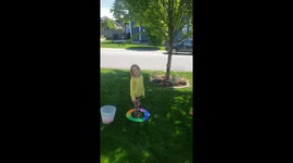 Little girls throwing water balloons at a tree