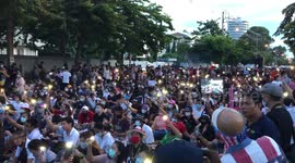 Thai protesters sing songs and wave phone lights outside parliament
