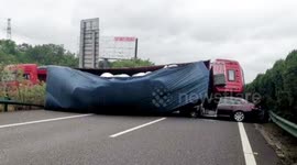 Chinese motorist luckily escapes death after transport truck flips on car on highway