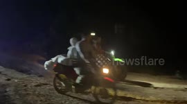 Bizarre moment paramedic straps mummified dead woman to his back while riding motorcycle