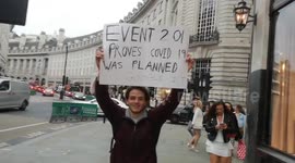 Anti-mask protestor holds sign In London's Regent Street