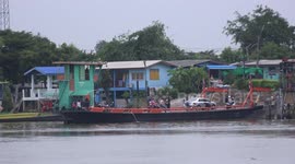 A small car ferry boat leaves port, only to return again one minute later when more passengers turn up.