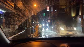 Taxi drives through flooded road In Bangkok after thunderstorms