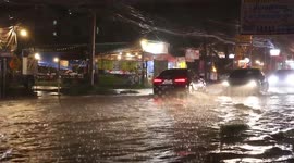 Vehicles plough through floodwater after rain batters northeast Thailand