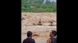 Dramatic rescue of man trapped on rock in flooded Indonesian river