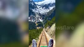 This vertigo inducing footage shows a first person perspective of a picturesque journey on a rollercoaster-like ride through the Swiss mountains.