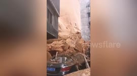 Mountainside collapses behind buildings killing one in central China