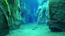 Diver explores crystal clear glacial water between Icelandic tectonic fissure