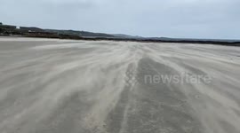 Watch as Storm Alex sandblasts everyone and everything on beach at St Michael's Mount, Cornwall