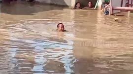 Stranded Locals Swim In Flooded Streets In The Philippines