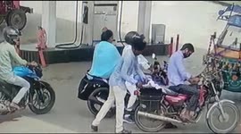 Moment brazen thief steals money from motorcycle as rider looks on at gas station