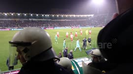 Greek football fan throws flare onto dugout during violent match