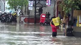 Shop worker plunges into hole during floods in Bali, Indonesia