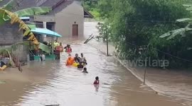 Police rescue women from waist height floods in Bali, Indonesia