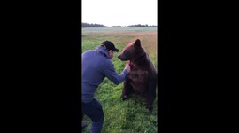 Man feeds the bear with honey