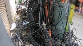A series of electrical wires are tangled like a spider web, electric poles are covered with electric wires in Vietnam