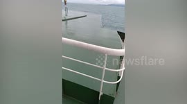 Two fishermen rescued by passing ferry after capsizing in choppy seas