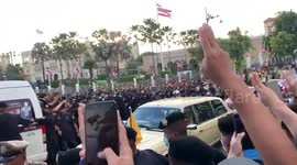 Pro-democracy protesters hold up three-finger salute as Thai king drives through crowd