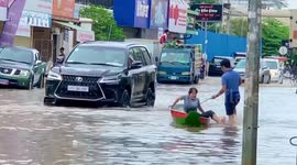 Residents use boat on flooded roads in Phnom Penh, Cambodia
