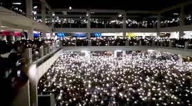 Hundreds of Thai student protesters wave flash lights and sing