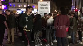 Crowd gathers outside Tottenham Court Road tube station in London to continue partying