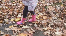 Toddler walking in Autumn Leaves