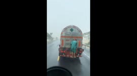 Vietnamese man attaches himself to back of truck to cross flooded road