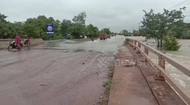 Swollen river covers bridge during floods in Cambodia