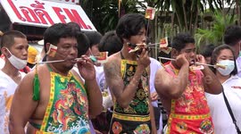 Religious devotees pierce their cheeks with skewers in Thailand