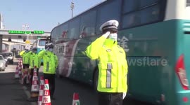 Police officers salute paramedics after they help test over 9 million people for coronavirus in China's Qingdao