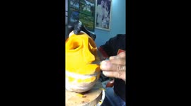 Vietnamese chef sculpting the Halloween pumpkin devil from the pumpkin