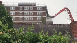 High-rise being demolished by 'dinosaur-like' jawed crane