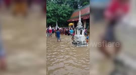 Buddhist worshippers perform religious ceremony at flooded temple in Thailand