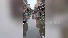 Flooded street filled with garbage after Tropical Storm Ofel brings heavy rain to Cambodia