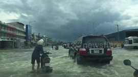 Drivers battle through flooded road in Phnom Penh, Cambodia