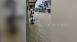 Locals have fun floating down flooded streets on rubber rings in the Philippines