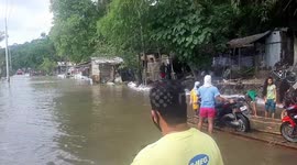 Motorcyclists cross flooded river on bamboo raft in Philippines