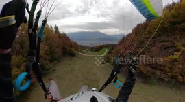 Speed flyer grazes autumnal foliage during his rapid descent down Austrian mountain
