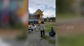 Truck gets stuck under low arch in Cambodia