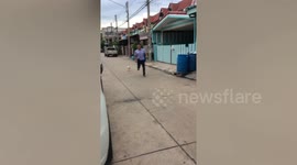 Aggressive chicken chases man down the road in Thailand