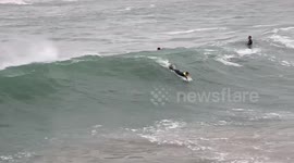Surfers catch large waves from ex-Hurricane Epsilon in Cornwall, UK