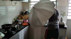 Man adopts ridiculous protective stance while cooking in his kitchen