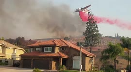 Firefighting plane battling Blue Ridge Fire drops fire retardant on homes