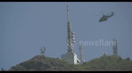 Daring helicopter rescue in Hong Kong, where rescue services winch up a victim meters away from a cliff on Kowloon Peak