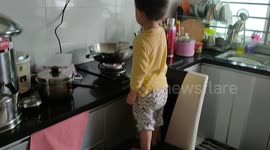 Little 2-year-old chef cooking in kitchen