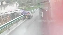 Chinese motorcyclist jumps over guardrails on roadside to avoid being hit by out-of-control truck